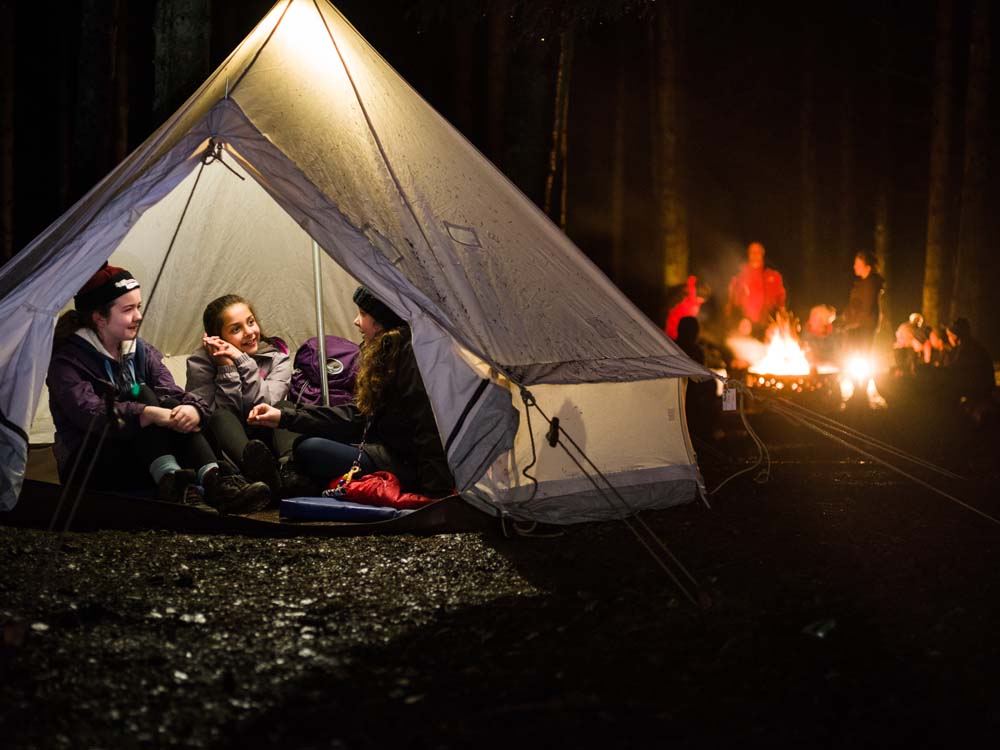 Cubs - Sitting in tent/ There is a fire in the background of the picture