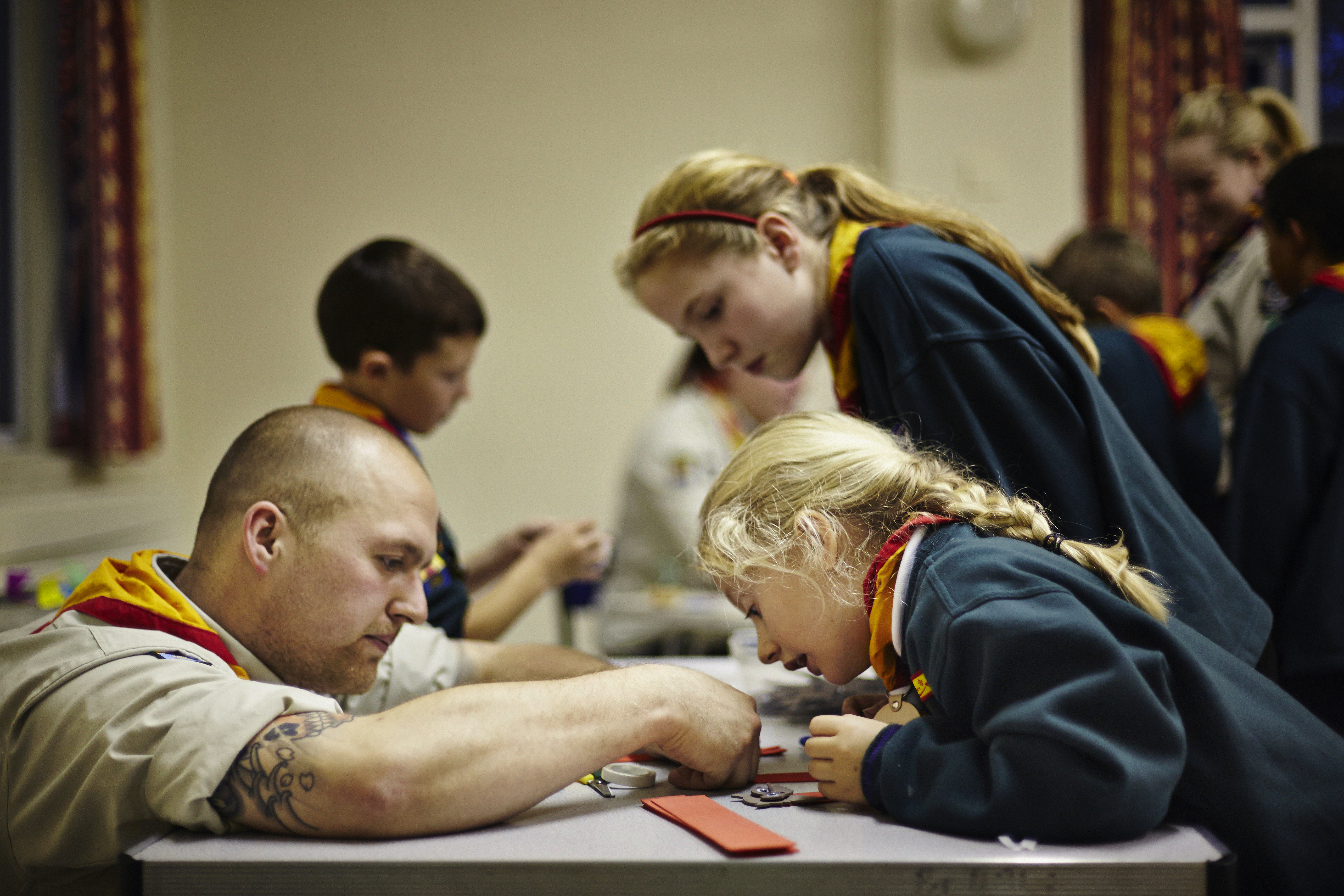 Scouts getting help from a leader/ volunteer